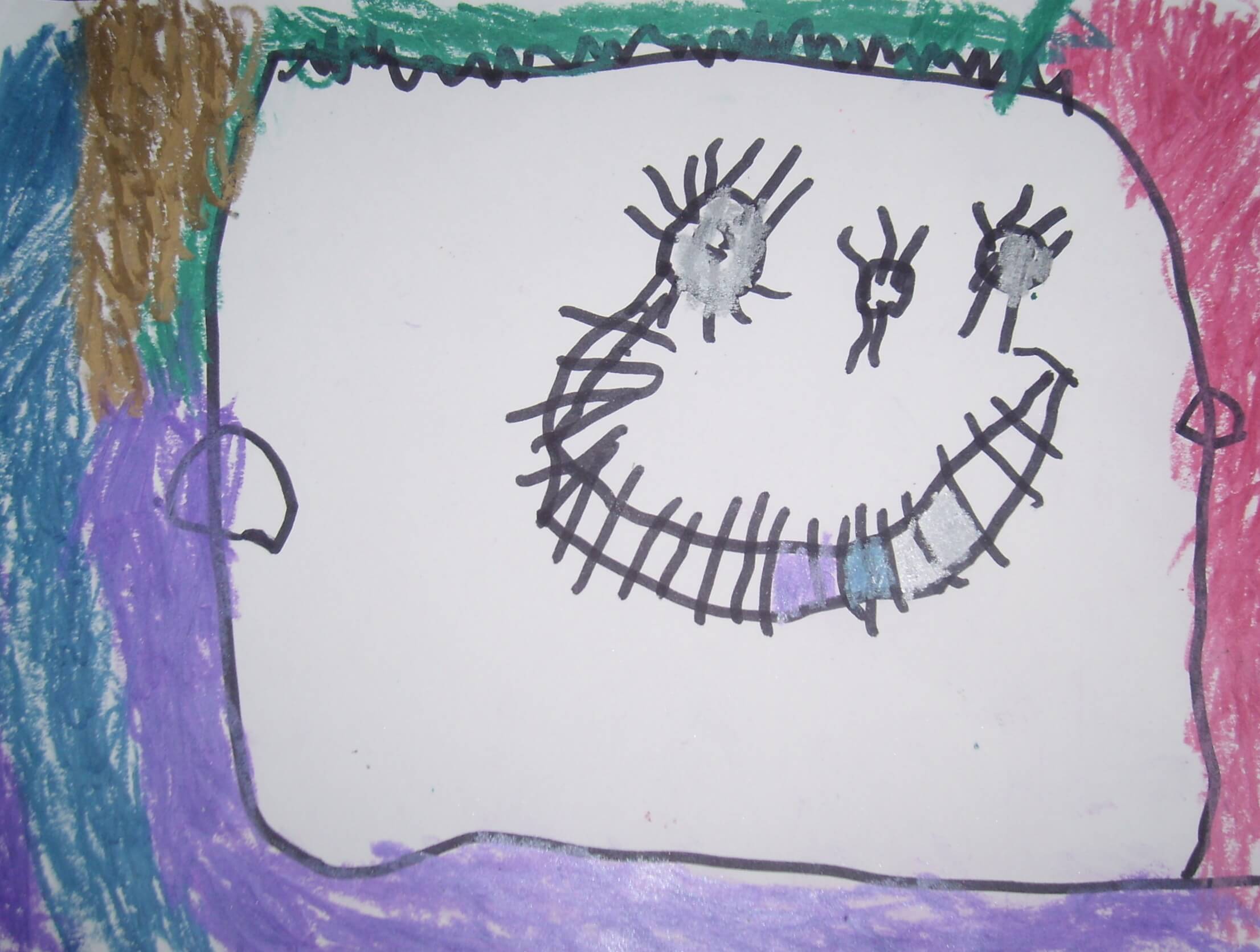 Hoja con una cara grande dibujada con líneas negras y rodeada de trazos de colores; se ven ojos, nariz y una sonrisa.